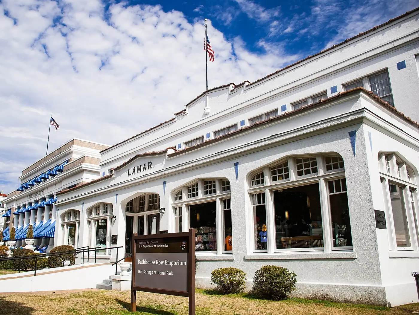 The white Lamar Bathhouse on Bathhouse Row in Hot Springs, with its sign out front