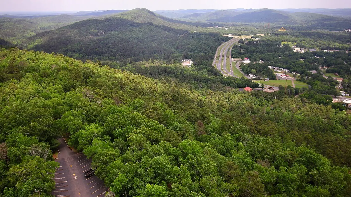 Forested Ouachita ridges and a highway seen from high above Hot Springs